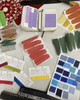 Open sketchbook featuring colour swatches alongside handwritten numbers and detailed records of each colour mix, illustrating meticulous documentation of pigment formulations and final colour choices.